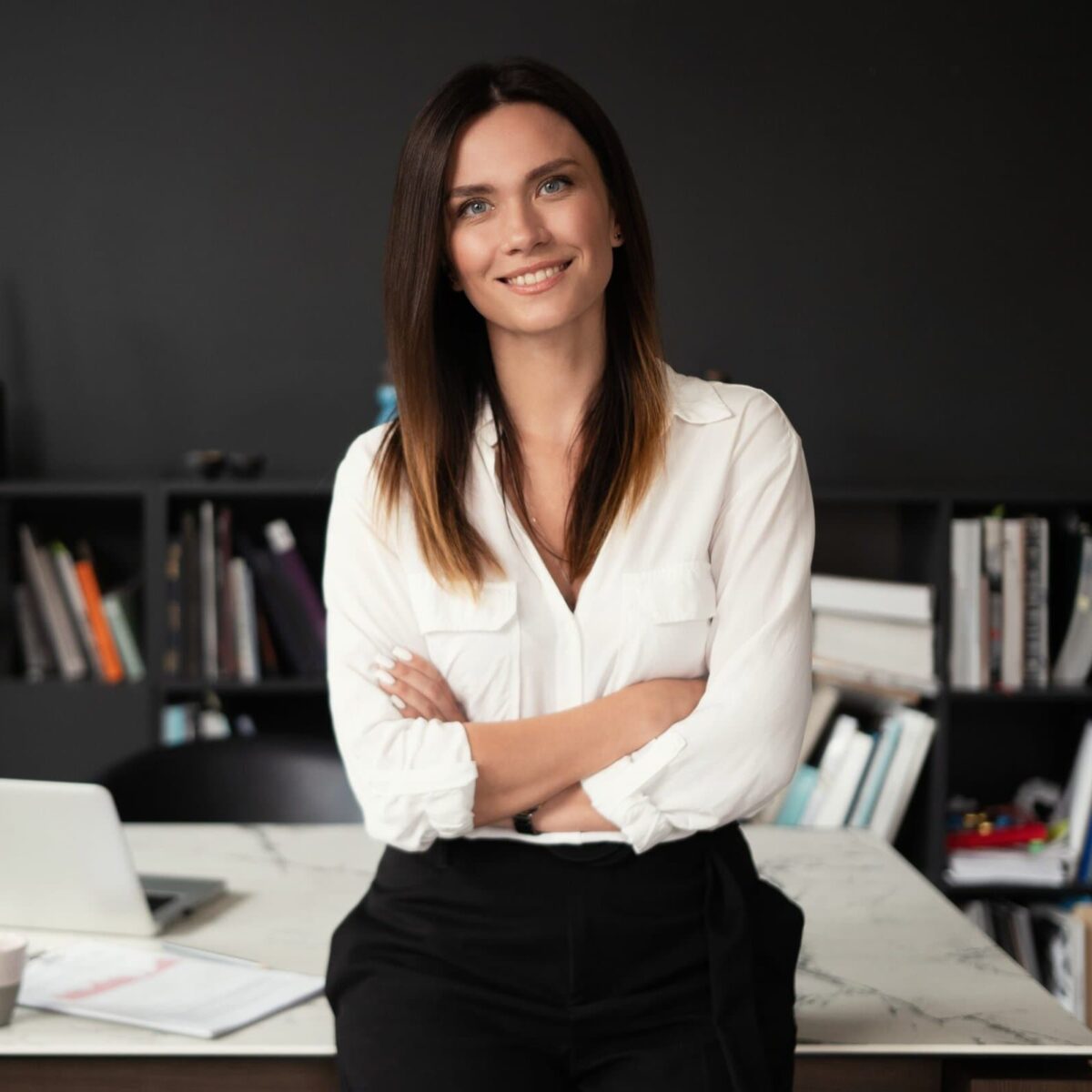 Confident stylish european middle aged woman standing at workplace, 30s lady executive leader manager looking at camera