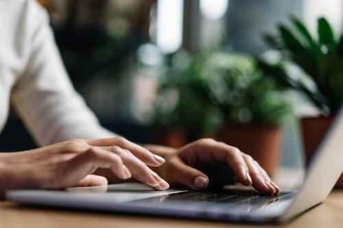 closeup photo of a hand while using a laptop