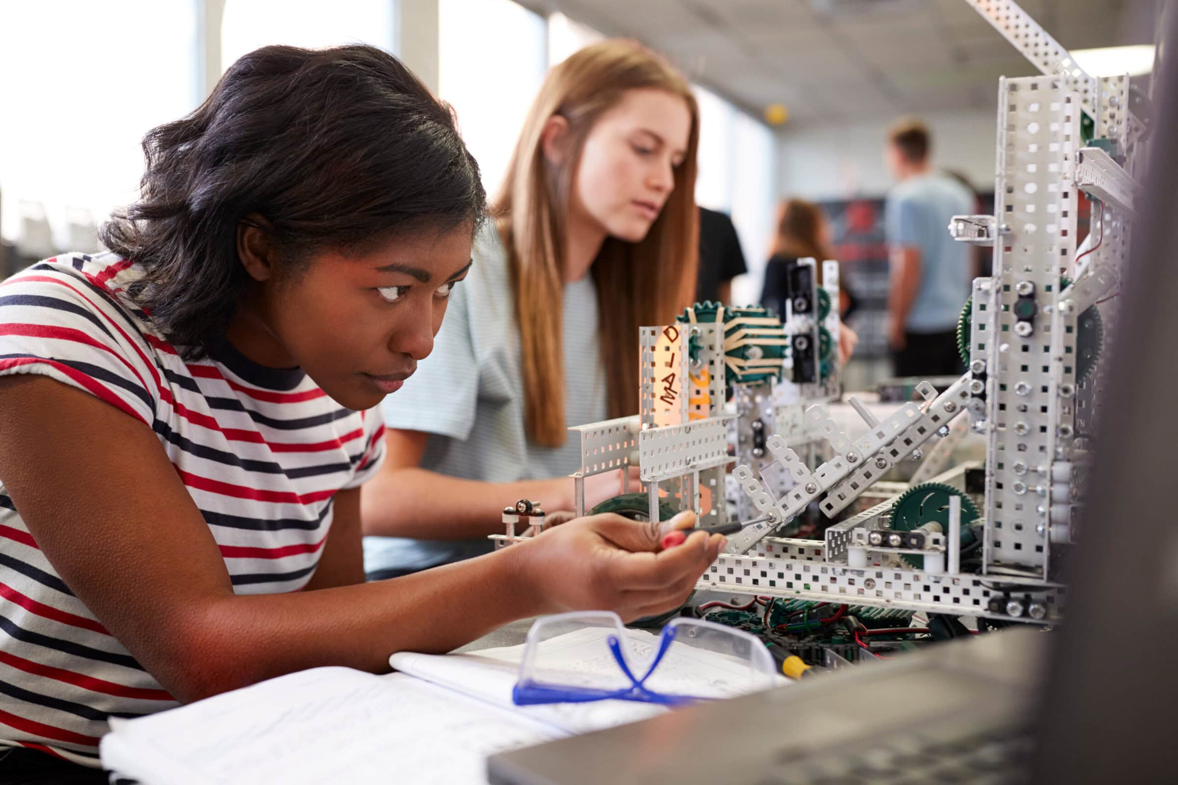 Two Female College Students Building Machine In Science Robotics Or Engineering Class Two Female College Students Building Machine In Science Robotics Or Engineering Class