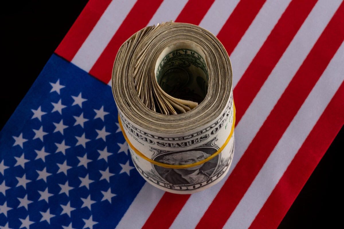 Bundle of 1 American dollar bills against the background of the American flag