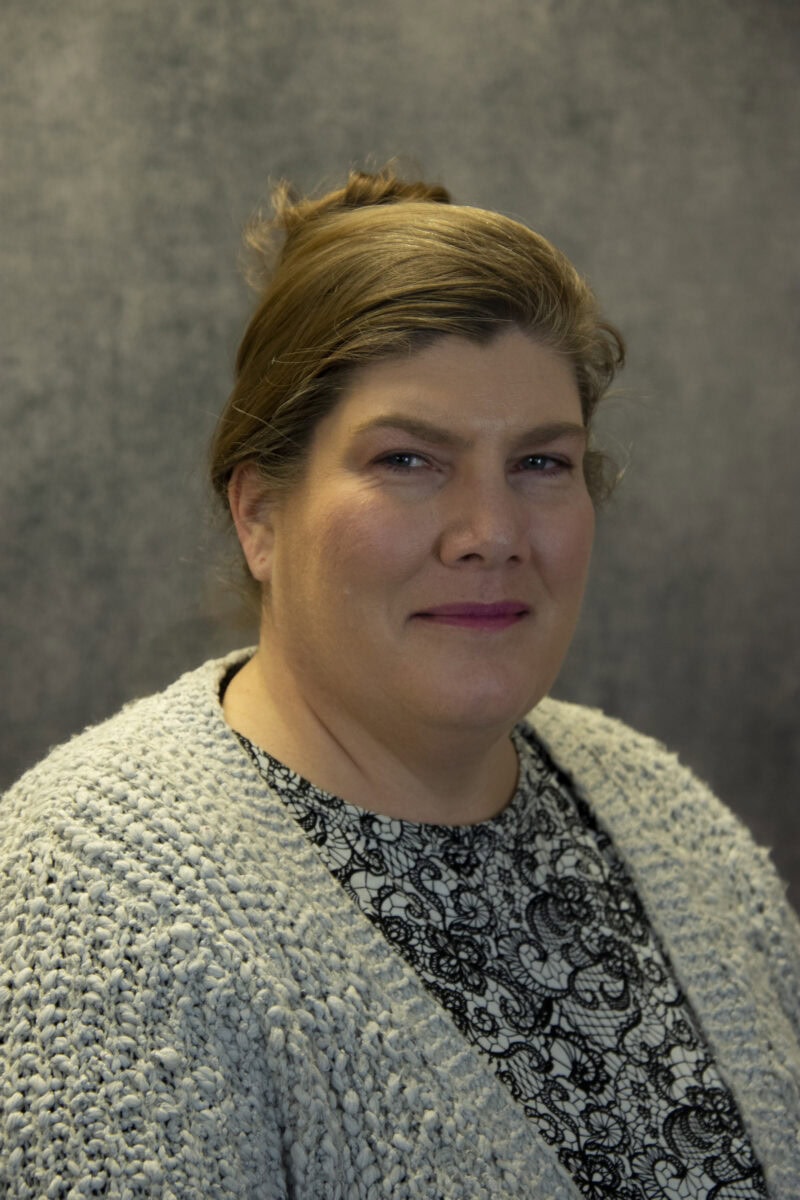 A portrait picture of Dawn Willhelm in a white sweater and blue blouse.