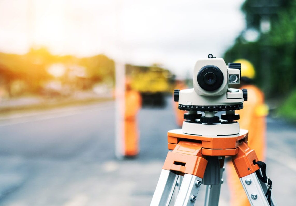 Surveyor’s telescope at new road construction site