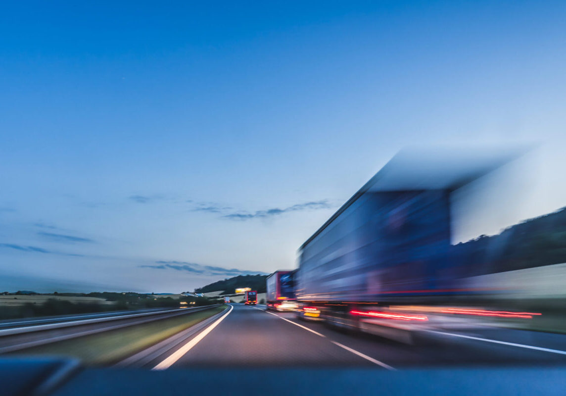 Background photograph of a highway. Truck on a motorway, motion