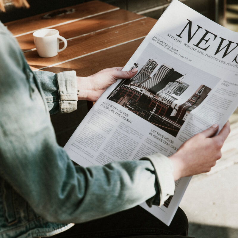 Woman reading a newspaper in a cafe