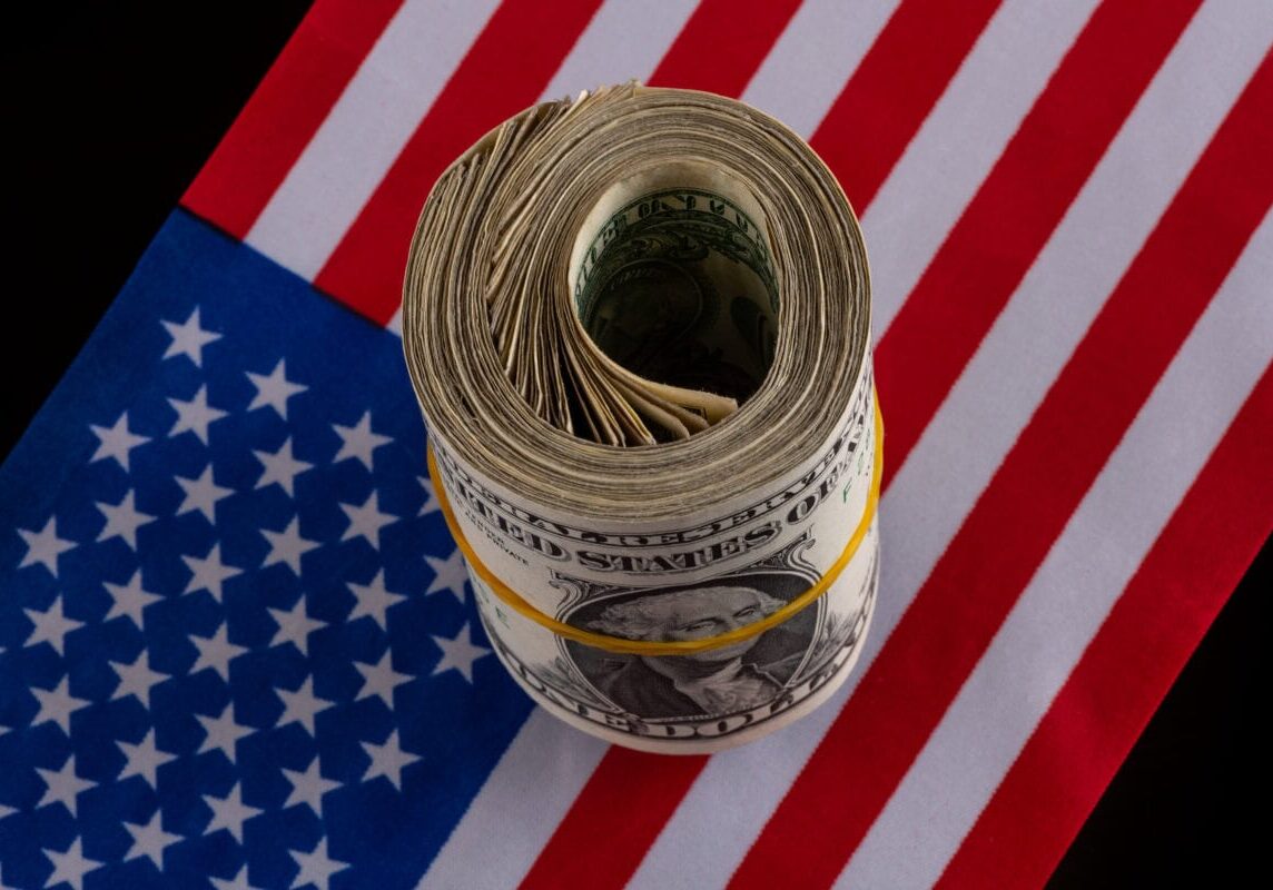 Bundle of 1 American dollar bills against the background of the American flag