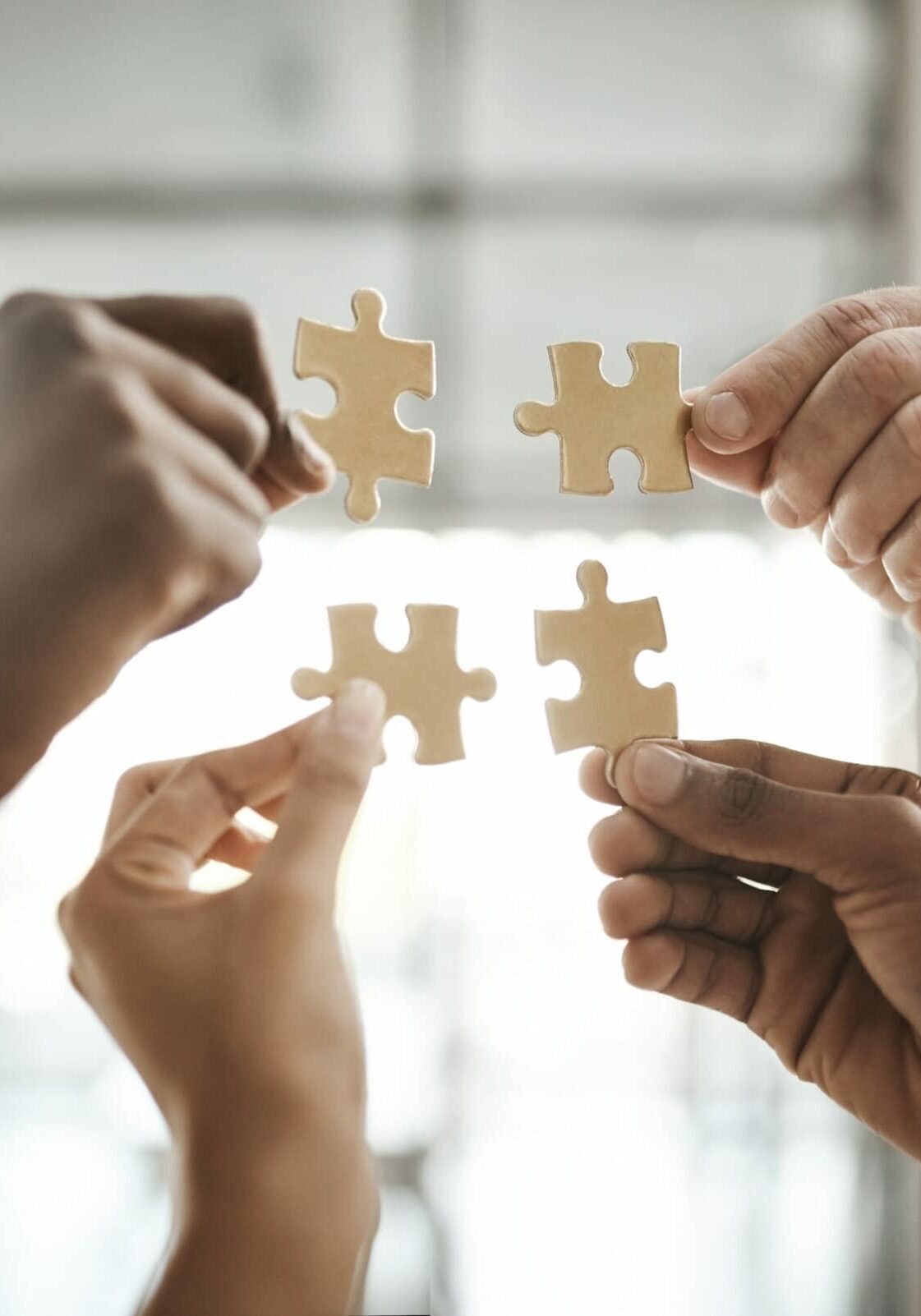 Diverse team solving a problem together due to teamwork, support and helping each other in the office. Group of business people assembling a puzzle and collaborating in unity Group of business people assembling a puzzle and collaborating in unity.