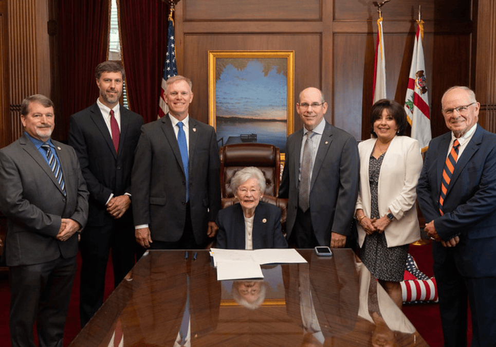 Attendees at the Alabama Dam Safety Act bill signing (l to r): Jeff Smitherman, Director, Alabama Emergency Management Agency; Chris Crawford, PE (TTL), President, ACEC/Alabama; Lawren Pratt, PE (Barge Design Solutions), ACEC/ASCE; Alabama Governor Kay Ivey; Senator Clyde Chambliss, PE (Chambliss Engineering), Alabama State Senate; Renee Anne Casillas, Executive Director & CEO, ACEC Alabama; and Steve Newton, PE (TTL), ACEC/ASCE.