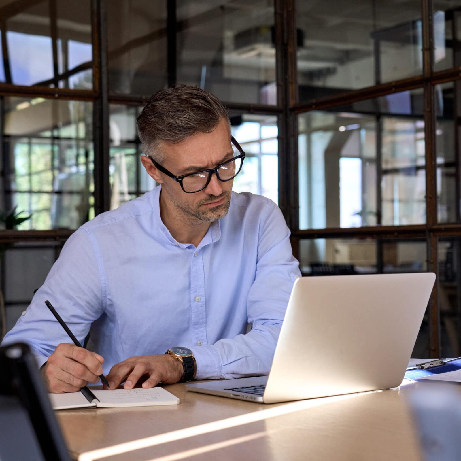 Mature business man executive manager looking at laptop computer watching online webinar