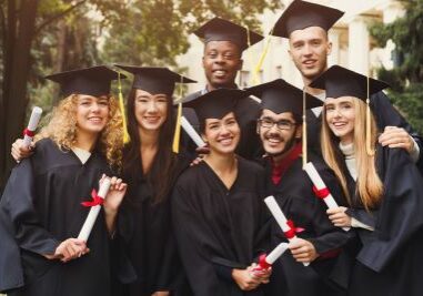 group of young individuals wearing their black graduation gown while holding their diplomas