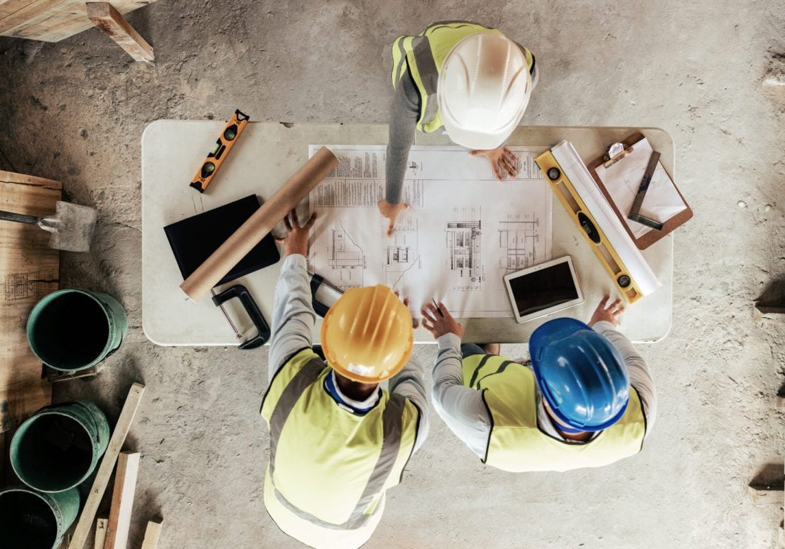 Top view, construction workers or blueprint planning in house, home or office building in real estate, property or architecture innovation. Men, engineering woman or construction site people or ideas.