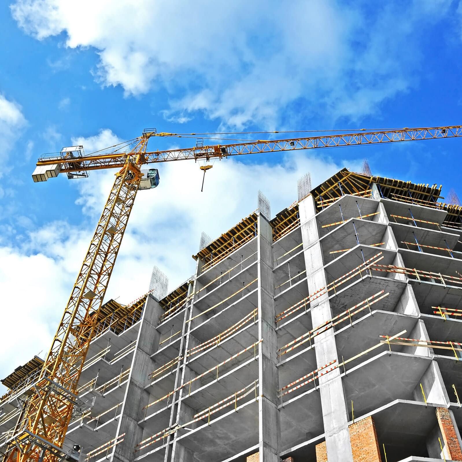 Crane And Building Construction Site Against Blue Sky